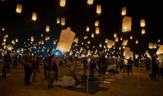 Participants team up to inflate their lanterns and release them during the Rise Lantern Festival at Jean Dry Lake Bed on Saturday, Oct. 18, 2014, in Jean.
