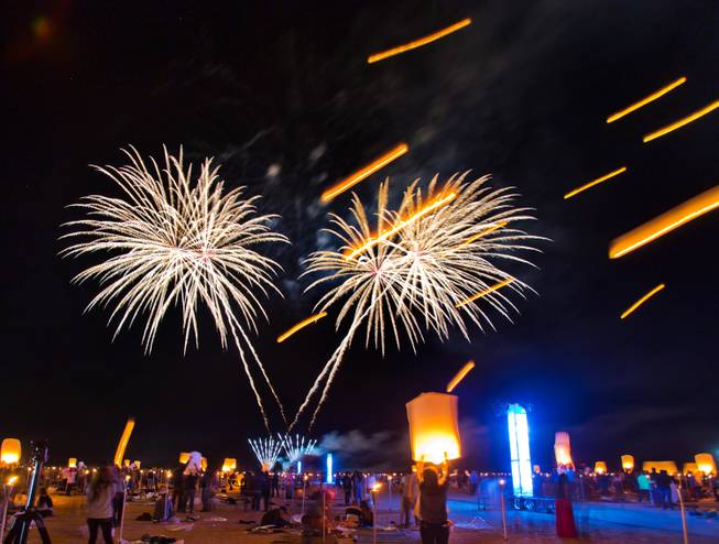 Fireworks burst in the night sky as participants continue to release more lanterns during the Rise Lantern Festival at Jean Dry Lake Bed on Saturday, Oct. 18, 2014, in Jean.