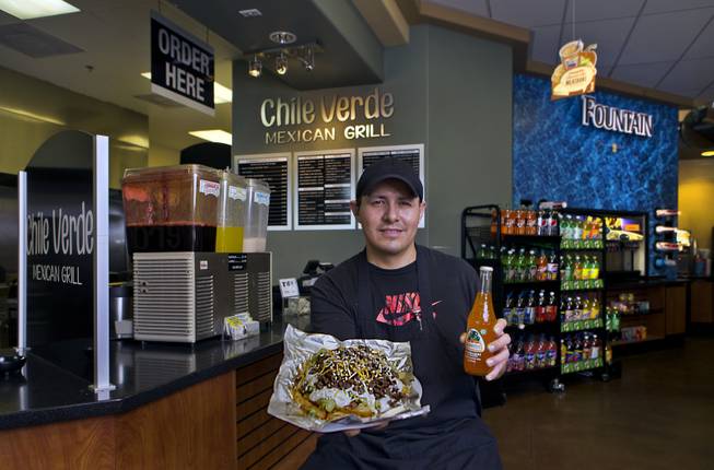 Carlos Cervantes operates Chile Verde Express within the Choice Gas Station on Wednesday, October 15, 2014. He prepares tasty meals like carne asada fries which pairs well with a Mexican soda.