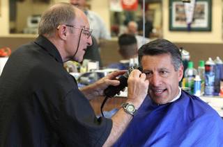 Barber Don Diehl cuts Gov. Brian Sandoval's hair, in Sparks, Nev., on Thursday, Oct. 14, 2014. Sandoval says going to the Paradise Park Barber Shop is a family tradition..Photo by Cathleen Allison