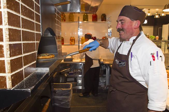 Michael Nagel takes a pizza from the oven at the new Fulton Street Food Hall at Harrahs Las Vegas Wednesday, Oct. 22, 2014.