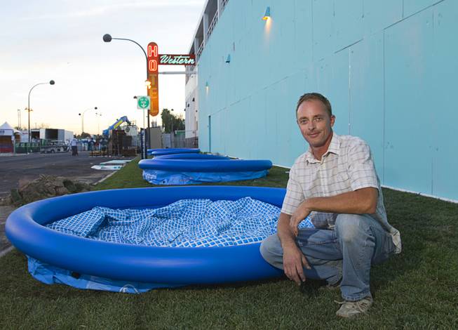 Artist Eric Tillinghast of Los Angeles poses by inflatable pools that will be part of his water slide installation at the Western Hotel in downtown Las Vegas Wednesday, Oct. 22, 2014.
