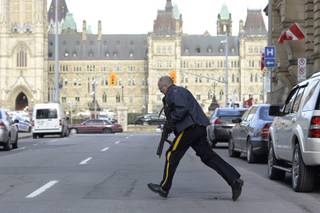 Police secure an area around Parliament Hill in Ottawa on Wednesday Oct. 22, 2014.  A soldier standing guard at the National War Memorial was shot by an unknown gunman and people reported hearing gunfire inside the halls of Parliament. Prime Minister Stephen Harper was rushed away from Parliament Hill to an undisclosed location, according to officials. (AP Photo/The Canadian Press, Adrian Wyld)