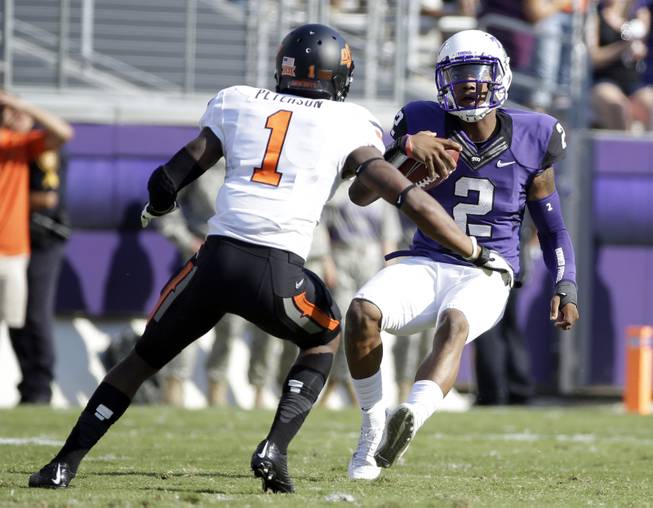 Oklahoma State cornerback Kevin Peterson (1) closes in as TCU quarterback Trevone Boykin (2) prepares to slide after a long run in the first half of an NCAA college football game, Saturday, Oct. 18, 2014, in Fort Worth, Texas. (AP Photo/Tony Gutierrez)
