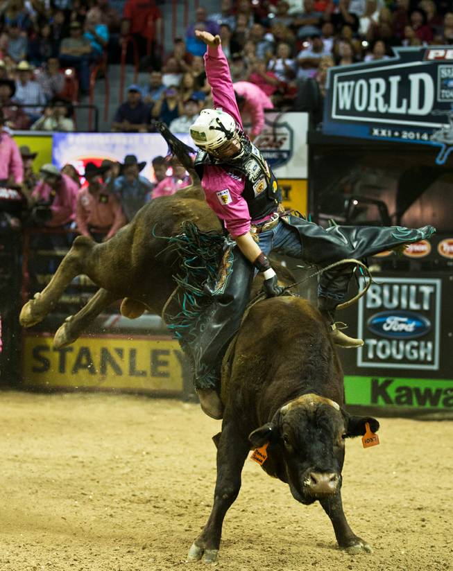 Gage Gay works hard to stay atop of Cooper Tires Brown Sugar  during the PBR 2014 World Finals on Thursday, October 23, 2014. L.E. Baskow.