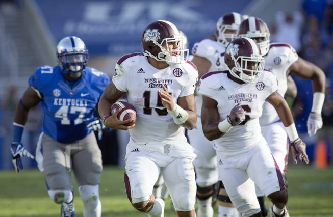 Mississippi State quarterback Dak Prescott runs for a first down against Kentucky at Commonwealth Stadium in Lexington, Ky., on Saturday, Oct. 25, 2014.