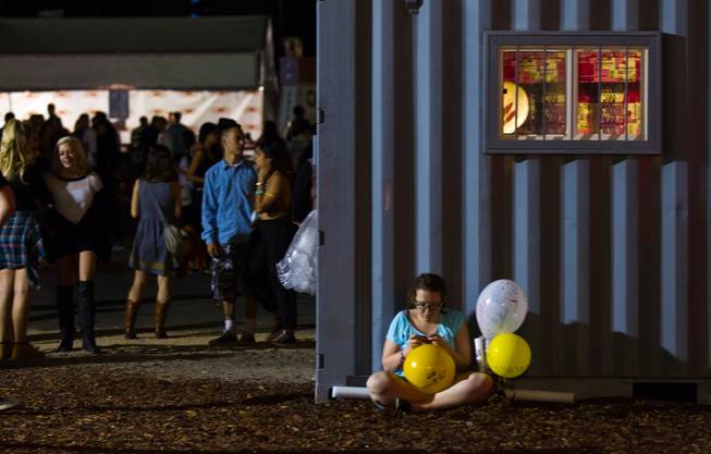 An attendee takes a break for some phone time during day 2 of the Life is Beautiful Festival on Friday, October 24, 2014.