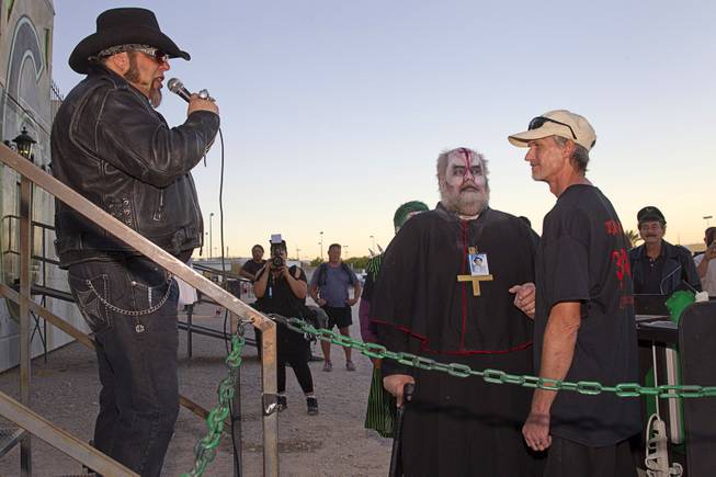 "Hellvis" serenades Jeff Burns, left, aka Cardinal Sin, and Michael Kimball with an Elvis song during their wedding at the Freakling Bros.' Trilogy of Terror haunted house attraction Wednesday, Oct. 29, 2014.