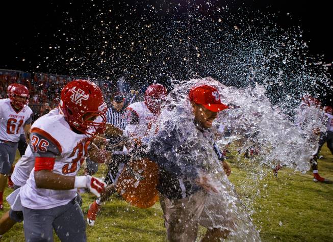Arbor View head coach Dan Barnson is blasted with a cooler of water after his team beat Centennial 20-16 on Thursday, October 30, 2014.