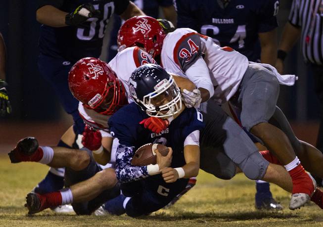 Centennial QB Juan Rodriguez 6 is taken down by the neck by Arbor View's Gage Motl 22 with Herman Gray 34 on Thursday, October 30, 2014.