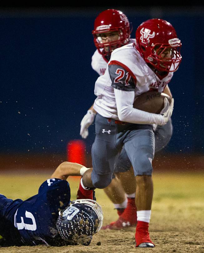 Arbor View's Charles Louch 21 breaks away from a leg tackle attempt by Centennial's Nik Dobar 33 on Thursday, October 30, 2014.