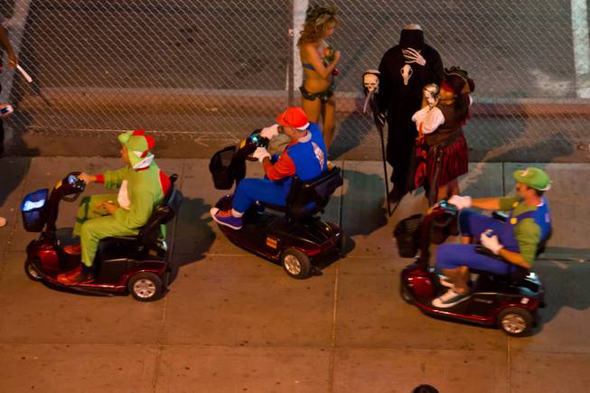 Yoshi, Mario and Luigi make their way through the crowd on their "karts" during the 2014 Las Vegas Halloween Parade, Friday Oct. 31, 2014.