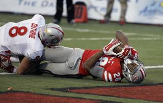 UNLV running back Keith Whitely scores a touchdown by New Mexico defensive back David Guthrie during their NCAA football game Saturday, Nov. 1, 2014, in Las Vegas. New Mexico won 31-28. (AP Photo/John Locher)