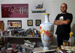 JW Caldwell poses by a ceramic vessel by artist Miguel Rodriguez  that will be part of Hammer & Cycle's third annual Bikes For Brats charity art auction.  