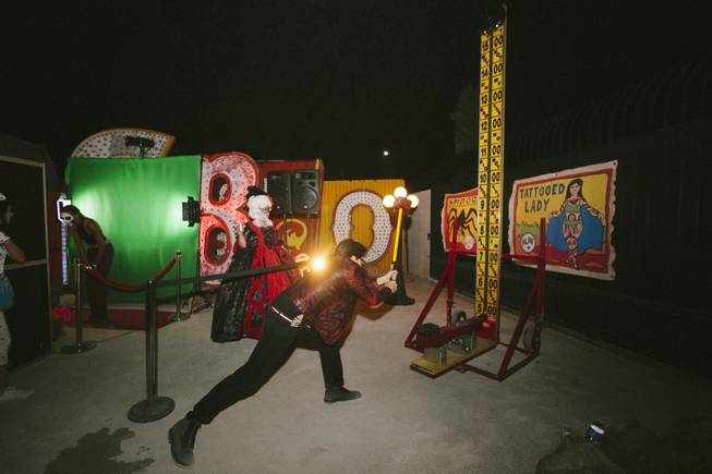A man takes a swing at a carnival game at the Neon Museum's Boneyard Bash Carnival Sideshow on October 31, 2014.