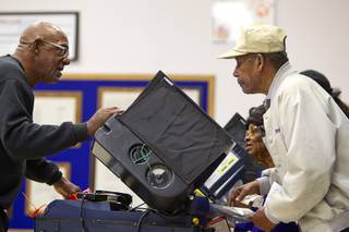 Election worker Preston Dagons helps Cornelius and Melvia Sanders as they vote at Jo Mackey Magnet Elementary School on Tuesday, Nov. 4, 2014, in North Las Vegas.