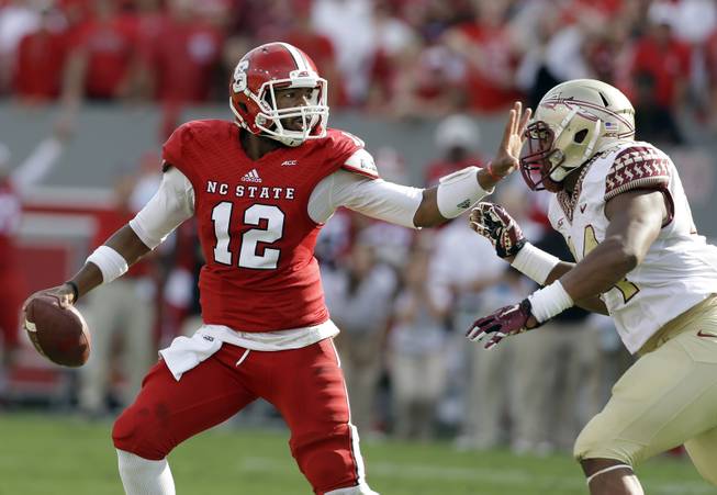 Florida State's DeMarcus Walker (44) rushes North Carolina State quarterback Jacoby Brissett (12) during the first half of an NCAA college football game in Raleigh, N.C., Saturday, Sept. 27, 2014. (AP Photo/Gerry Broome)
