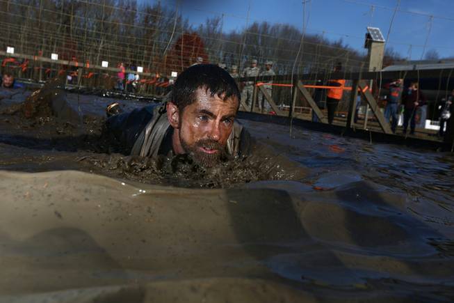 A competitor in the 2013 World's Toughest Mudder, held in Englishtown, N.J., slogs through mud on his belly. The 2014 World's Toughest Mudder, the culminating event for the obstacle course series, will be held at Lake Las Vegas Nov. 15-16.