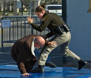 Metro Police Officer Nicole Hemsey takes down an aggressive suspect played by officer Chad Lyman during a demonstration of body worn cameras during a media at the Mohave Training Center on Wednesday, November 12, 2014.