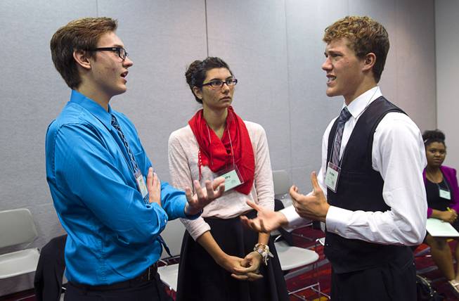 Timothy Schwappach, left, of Cimarron-Memorial High School, Destiny Farrant of Shadow Ridge High School, and Andrew Soule of Liberty High School debate genetics  as related to serial killers during the 58th annual Las Vegas Sun Youth Forum at the Las Vegas Convention Center Thursday, Nov. 13, 2014.