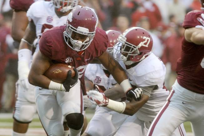 Arkansas running back Jonathan Williams, left, tries to get past Alabama defensive back Nick Perry (27) in the first half of an NCAA college football game in Fayetteville, Ark., Saturday, Oct. 11, 2014. (AP Photo/Sarah Bentham)