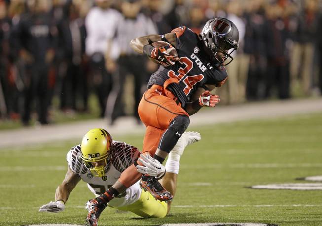 Oregon linebacker Tyson Coleman (33) tackles Utah running back Bubba Poole (34) in the second half during an NCAA college football game Sunday, Nov. 9, 2014, in Salt Lake City. (AP Photo/Rick Bowmer)