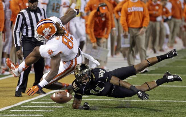 Wake Forest's Anthony Wooding Jr. (11) breaks up a pass intended for Clemson's Jay Jay McCullough (89) during the first half of an NCAA college football game in Winston-Salem, N.C., Thursday, Nov. 6, 2014. (AP Photo/Chuck Burton)