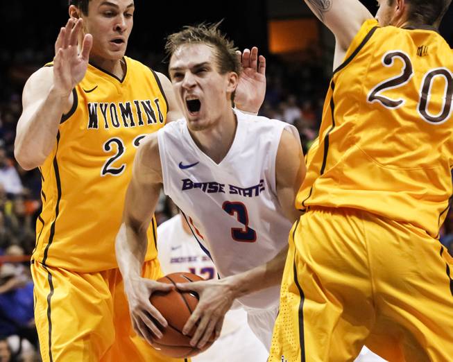 Boise State's Anthony Drmic (center) moves the ball between Wyoming's Larry Nance Jr. and Nathan Sobey during the second half in Boise, Idaho, on Saturday, Jan. 11, 2014. Wyoming defeated Boise State 52-50. 