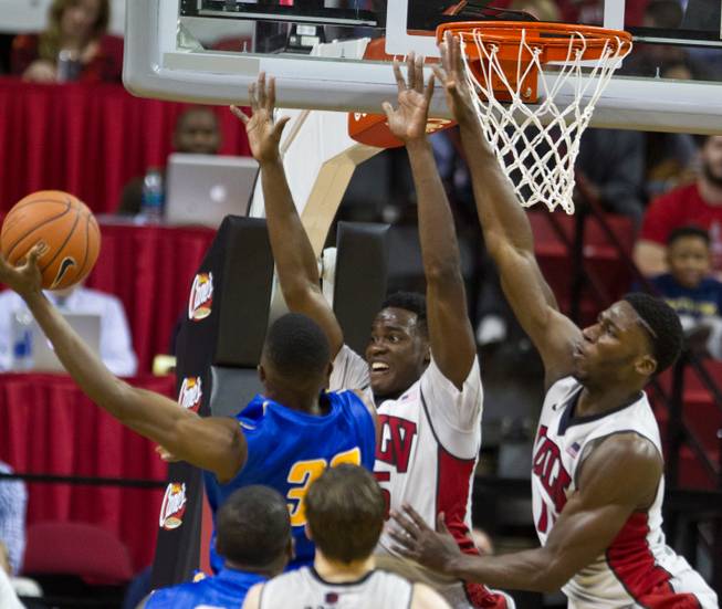 UNLV's Dwayne Morgan #15and  Goodluck Okonoboh #11 elevate under the basket while working to block a shot by Morehead State's Brent Arrington #32 during their home opener on Friday, November 14, 2014.