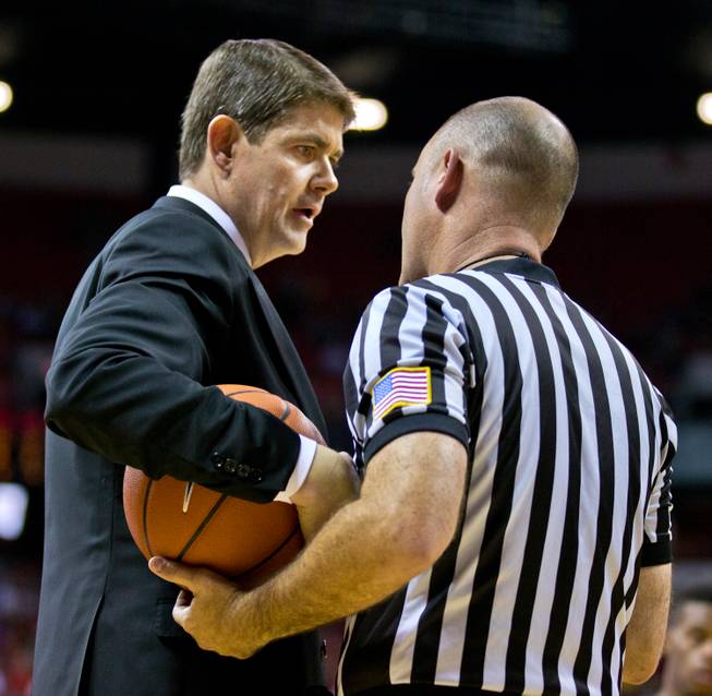 The UNLV men's basketball head coach Dave Rice politics a bit with an official during a timeout versus Morehead State on Friday, November 14, 2014.