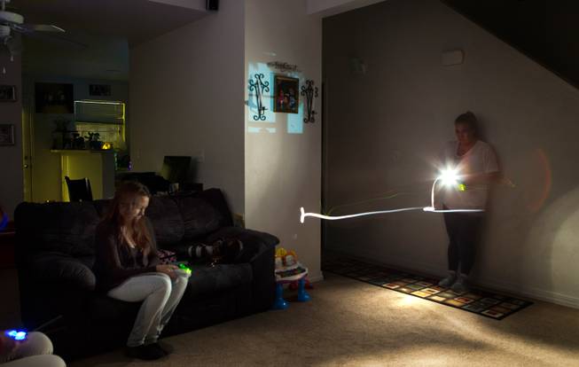 Valencia Vaughn and ghost hunter Jeannine Robertson listen for any audible signs of Vaughn's deceased brother she believes is appearing in her home on Friday, November 16, 2014.
