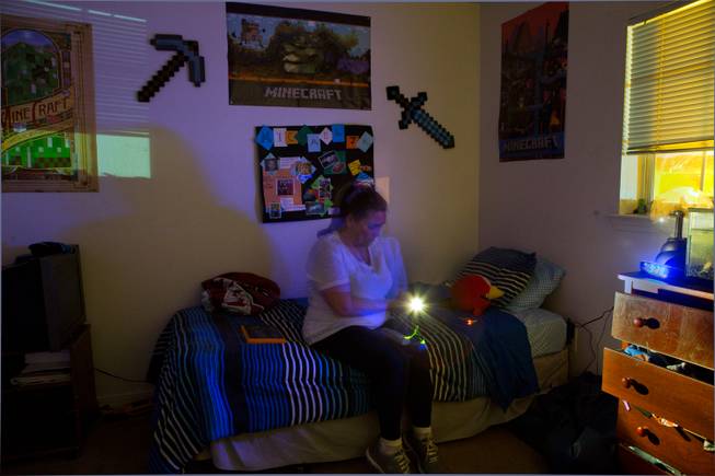 Ghost hunter Jeannine Robertson attempts to make contact with a spirit in an upstairs bedroom at the Vaughn home with detection equipment on Friday, November 16, 2014.