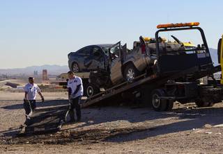 City Wide Towing operators pull the roof of an SUV onto a flatbed truck after a fatal accident on the 215 Beltway between 5th Street and Aliante Parkway Monday, Nov. 17, 2014.