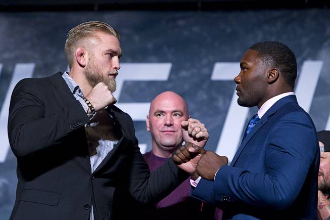 UFC light heavyweight fighters Alexander Gustafsson, left, and Anthony Johnson pose during a UFC news conference at the Smith Center for the Performing Arts Monday, Nov. 17, 2014. UFC president Dana White, center, looks on.