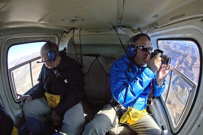 In this Oct. 5, 2013, photo, Geir Aase, left, and Kurt Raknes, tourists from Norway, take a helicopter tour over Grand Canyon National Park, near Tusayan, Ariz. A proposal by the Grand Canyon would give air tour operators another incentive to upgrade aircraft to meet the definition of quiet technology. 