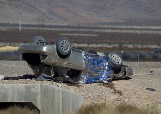 A sedan is shown on it's roof after a fatal rollover accident on the Interstate 15 South offramp to the westbound 215 Beltway Tuesday, Nov. 18, 2014. The male driver was killed, officials said.