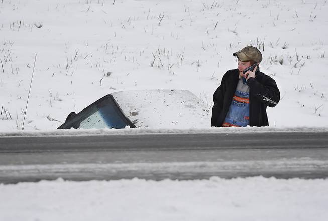 Caelan Slate, of Nortonville, Ky., calls to say he is going to be a little late to work after losing control and landing his truck in a ditch of off the Pennyrile Parkway in Henderson County, Monday, Nov. 17, 2014. The first winter storm of the season closed schools and made driving treacherous.
