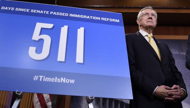 Senate Majority Leader Harry Reid stands next to a sign stating the number of days since the Senate passed immigration reform legislation, Thursday, Nov. 20, 2014, during a news conference on Capitol Hill in Washington. 
