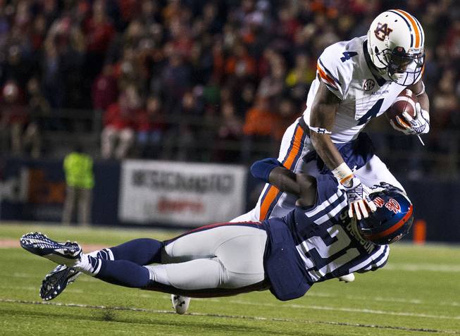 Mississippi defensive back Senquez Golson (21) tackles Auburn wide receiver Quan Bray (4) during the second half of an NCAA college football game Saturday, Nov. 1, 2014, in Oxford, Miss. (AP Photo/Brynn Anderson)