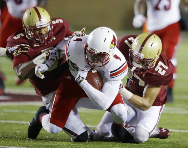 Louisville wide receiver DeVante Parker (9) is tackled by Boston College defensive backs Justin Simmons (27) and Ty-Meer Brown (5) during the first quarter of their NCAA college football game on the Boston College campus Saturday, Nov. 8, 2014 in Boston. (AP Photo/Stephan Savoia)