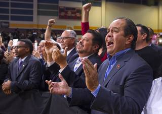 Michael Nowakowski, a Phoenix city councilman, center, and Eric Chavez, right, community director of the Chavez Institute for Law and Social Justice, react to President Obama's speech at Del Sol High School Friday, Nov. 21, 2014.