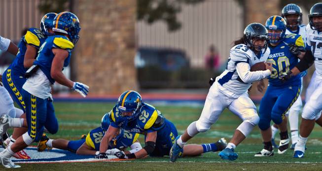 Desert Pines Trevor Nofoa #23 breaks free for a long run over the Moapa Valley defenders during the Division I-A state high school football championship game on Saturday, November 22, 2014.