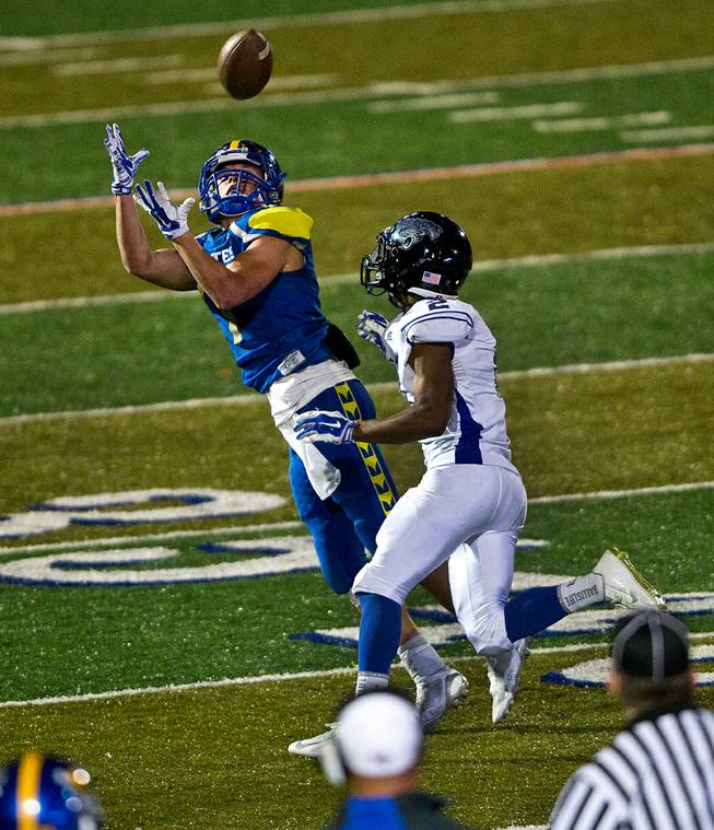 Moapa Valley's Cole Mulcock #7 looks to receive a long pass with Desert Pines Jordan Diggs #2 trailing during the Division I-A state high school football championship game on Saturday, November 22, 2014.