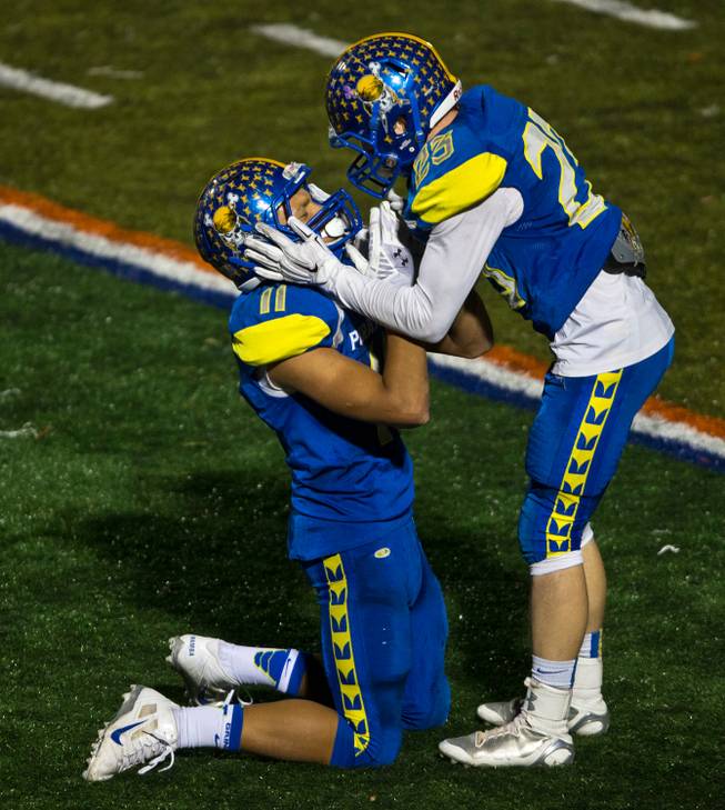Moapa Valley's Rj Hubert #11and Chace Traasdahl #25 celebrate their overtime tie during the Division I-A state high school football championship game on Saturday, November 22, 2014.