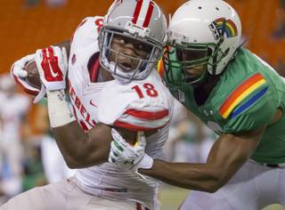 UNLV wide receiver Marcus Sullivan (18) is tackled by Hawaii defensive back Trayvon Henderson (39) after Sullivan caught a pass in the first quarter of an NCAA college football game, Saturday, Nov. 22, 2014, in Honolulu.