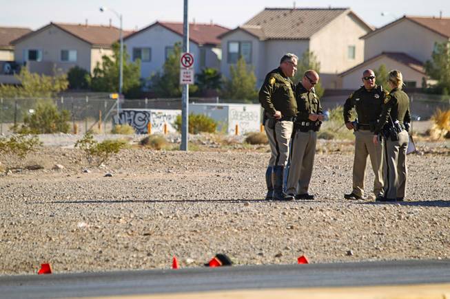 Metro Police officers confer near the area where a man and a baby were hit by a car on South Rainbow Boulevard near Warm Springs Road Monday, Nov. 24, 2014.