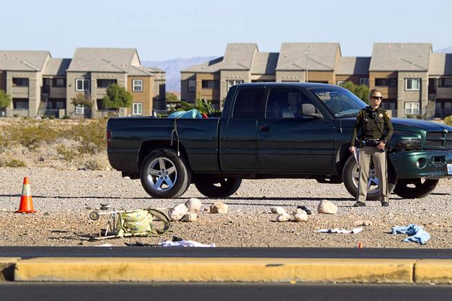 A Metro Police officer stands by the area where a man and a baby were hit by a car on South Rainbow Boulevard near Warm Springs Road Monday, Nov. 24, 2014.
