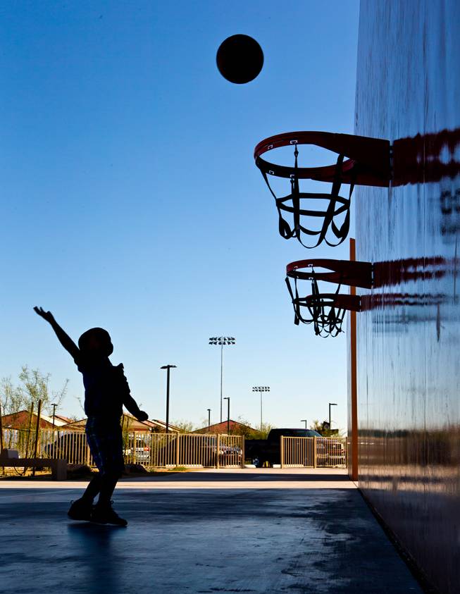 Akene Anyanwu, 3, practices his shot on the basketball court at Mountain's Edge Regional Park on Friday, November 21, 2014.
