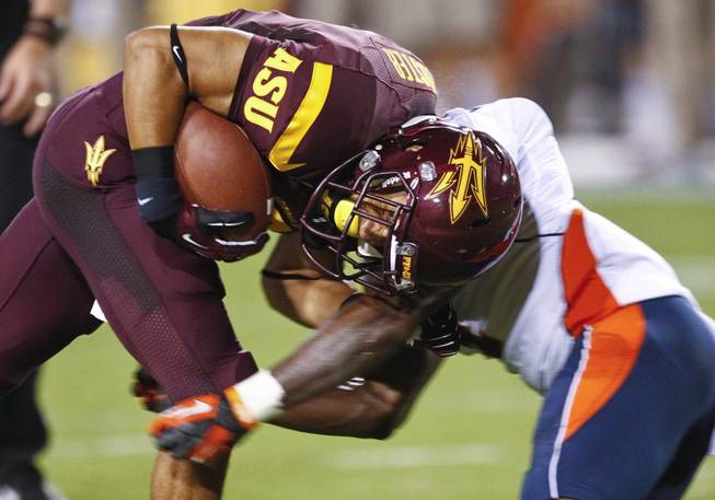 Arizona State running back D.J. Foster is stopped by llinois defensive back Patrick Nixon-Youman during the first half of an NCAA football game Saturday, Sept. 8, 2012, in Tempe, Ariz.