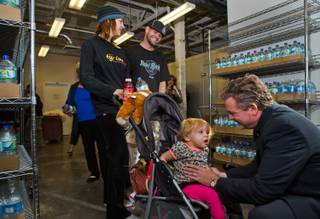 Catholic Charities new CEO Deacon Thomas Roberts greets Amelia Martin, 1, with her parents Bryn Martin and Alex Maynard shopping in the food pantry for Thanksgiving groceries on Tuesday, November 25, 2014. .